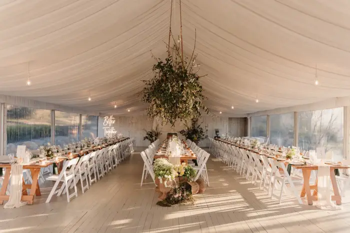 Marquee reception with a suspended greenery installation above the head table