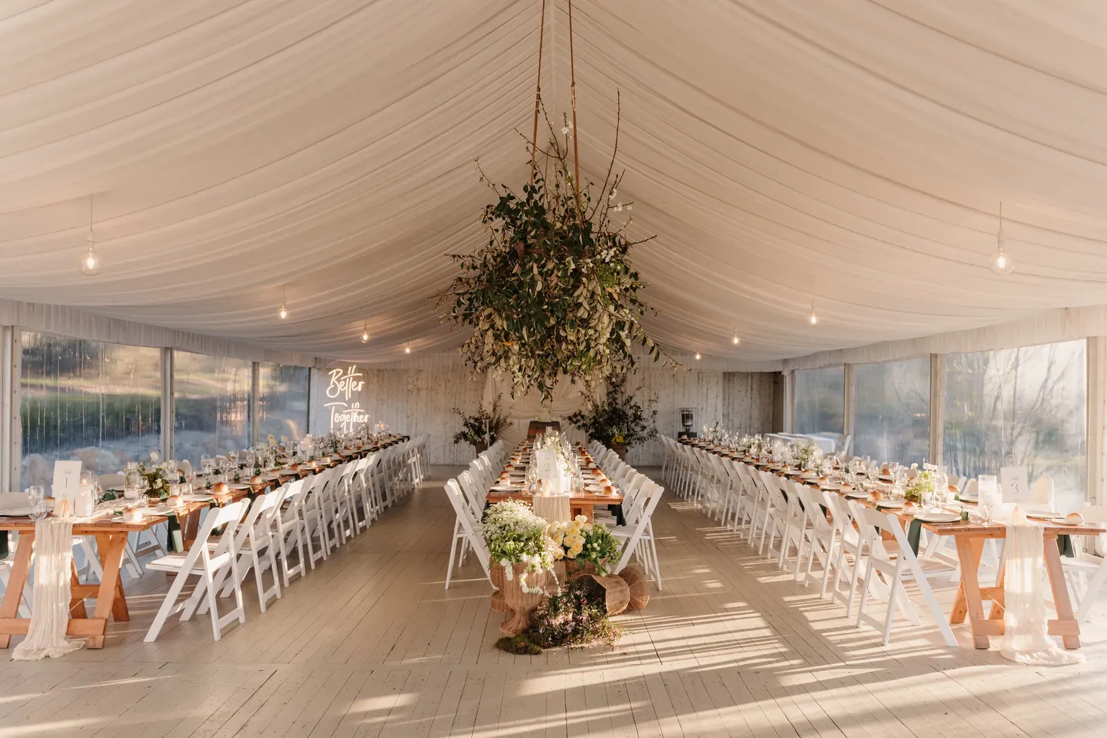 Marquee reception with a suspended greenery installation above the head table