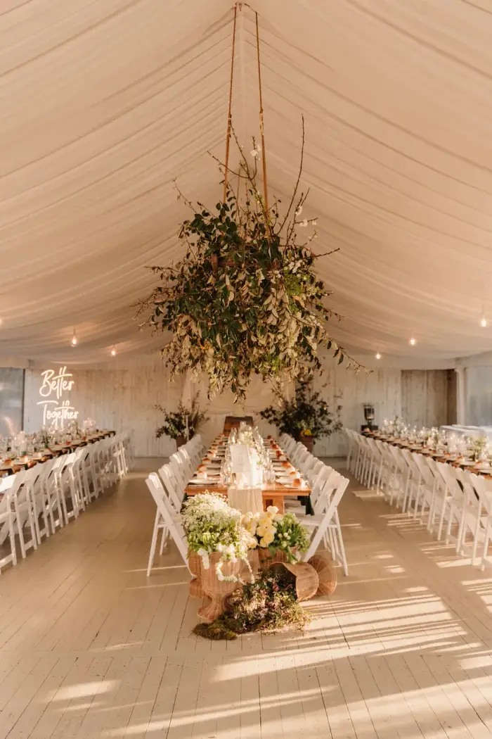 Hanging greenery and blossom installation over the marquee tables
