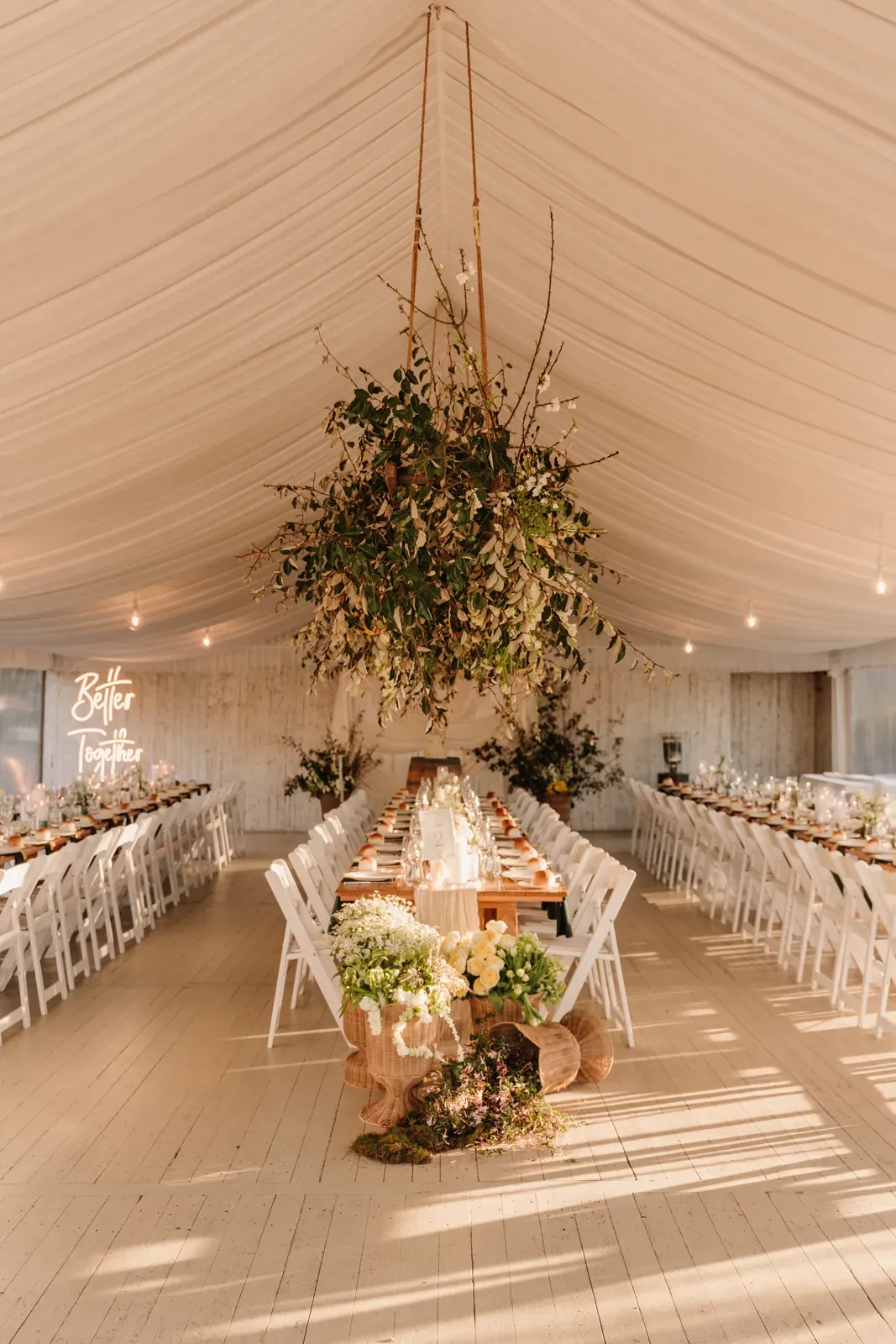 Hanging greenery and blossom installation over the marquee tables