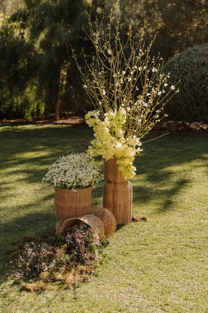 Tall blossom and yellow floral arrangement on stacked woven baskets