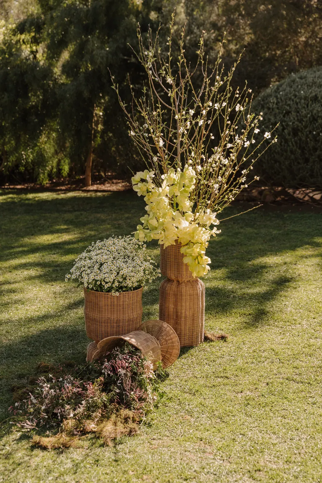 Tall blossom and yellow floral arrangement on stacked woven baskets