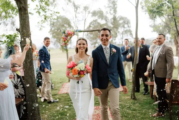 Bride and groom walking down the aisle through a confetti shower