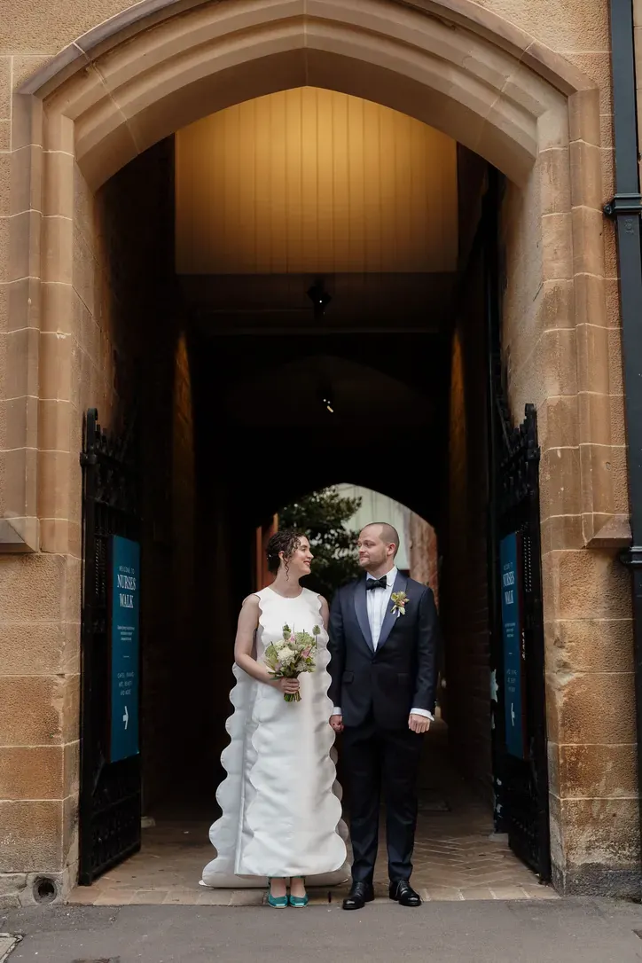 Bride and groom in a sandstone archway at the Museum of Contemporary Art