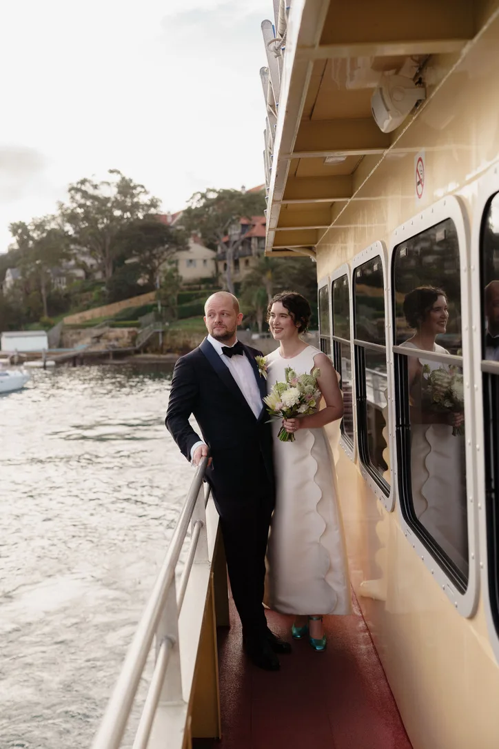Newlyweds holding a bouquet aboard a ferry